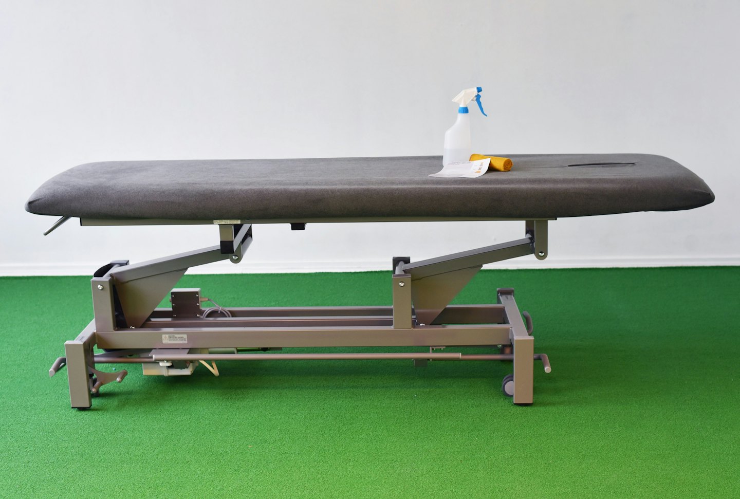 Leerer Therapieschreibtisch mit Sprühflasche und Reinigungsmitteln.